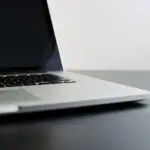 silver laptop computer on black table